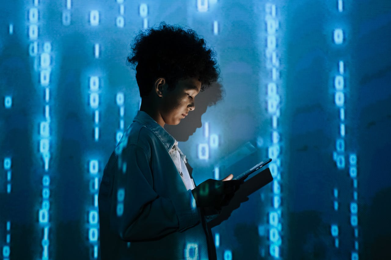 about-06 Teenage boy with a tablet surrounded by digital binary code in a studio setting.